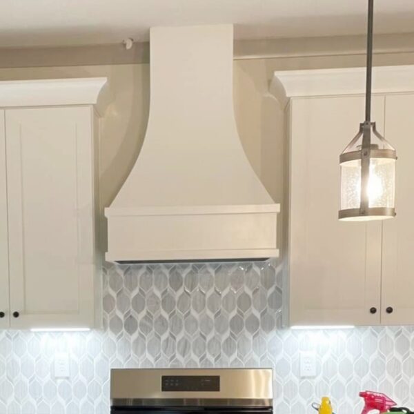 Curved custom wood range hood in white finish