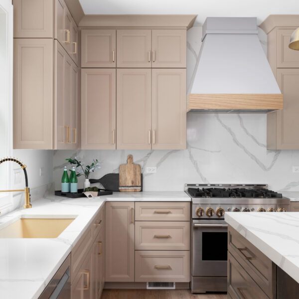 Custom painted wood range hood above brown cabinets and marble countertop