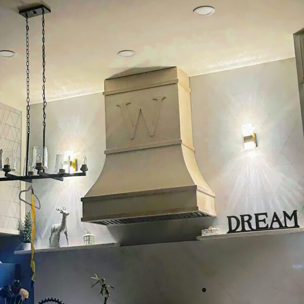 Custom wood range hood installed in kitchen