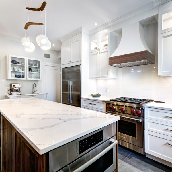Custom wood range hood with detailed vent cover in white kitchen